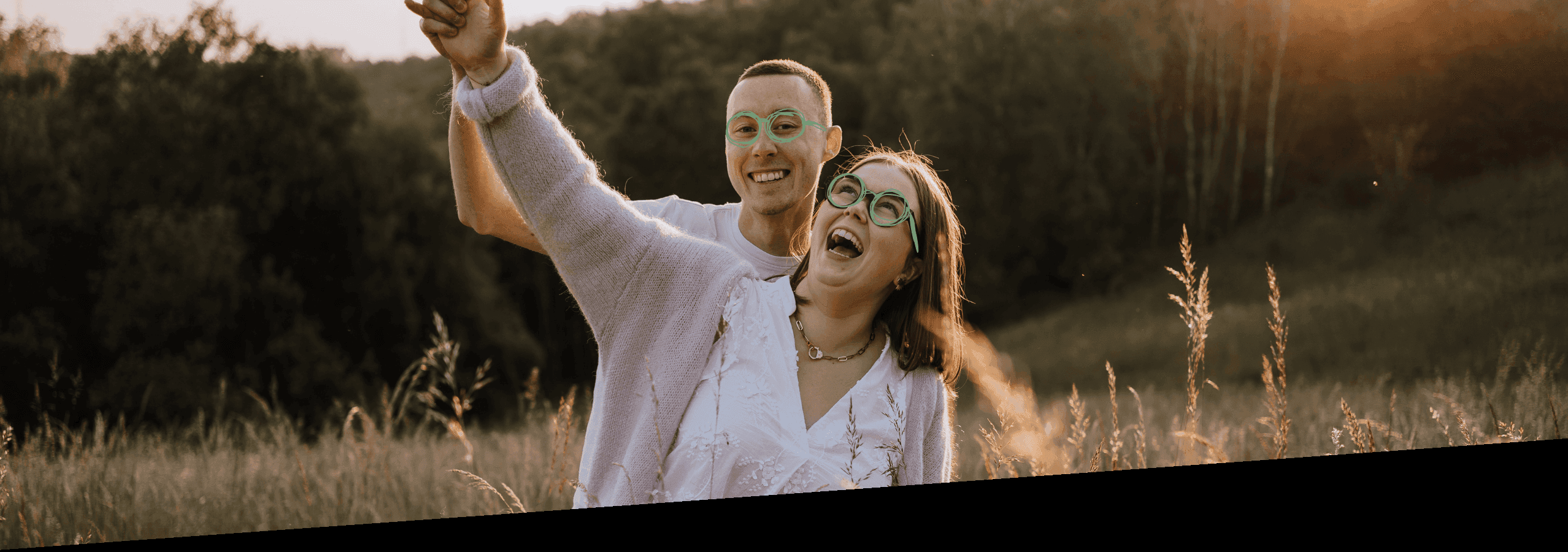 Pärchen lacht gemeinsam auf einer Wiese